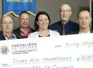 5 personnes souriantes tenant un chèque géant avec la mention ''Dons aux organismes'', d'un montant de 3240 $.