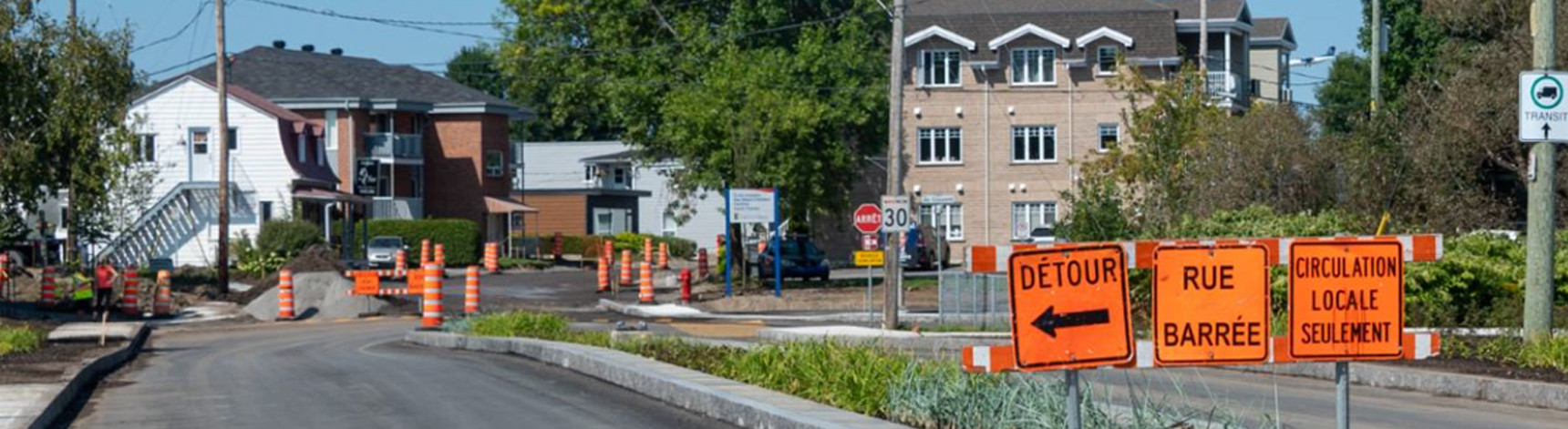 Rue Notre-Dame avec des panneaux oranges de signalisation de détours et plusieurs cônes au loin.