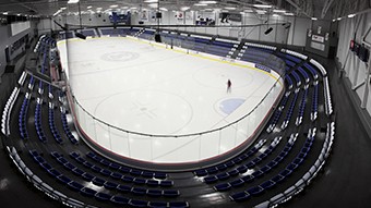 Patinoire intérieure avec estrades vides et aucun joueur.