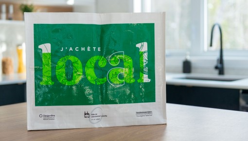 Sac réutilisable sur un comptoir de cuisine avec la mention J'achète local, aux couleurs de la Ville de L'ancienne-Lorette.