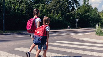 Deux écoliers qui traversent la rue.