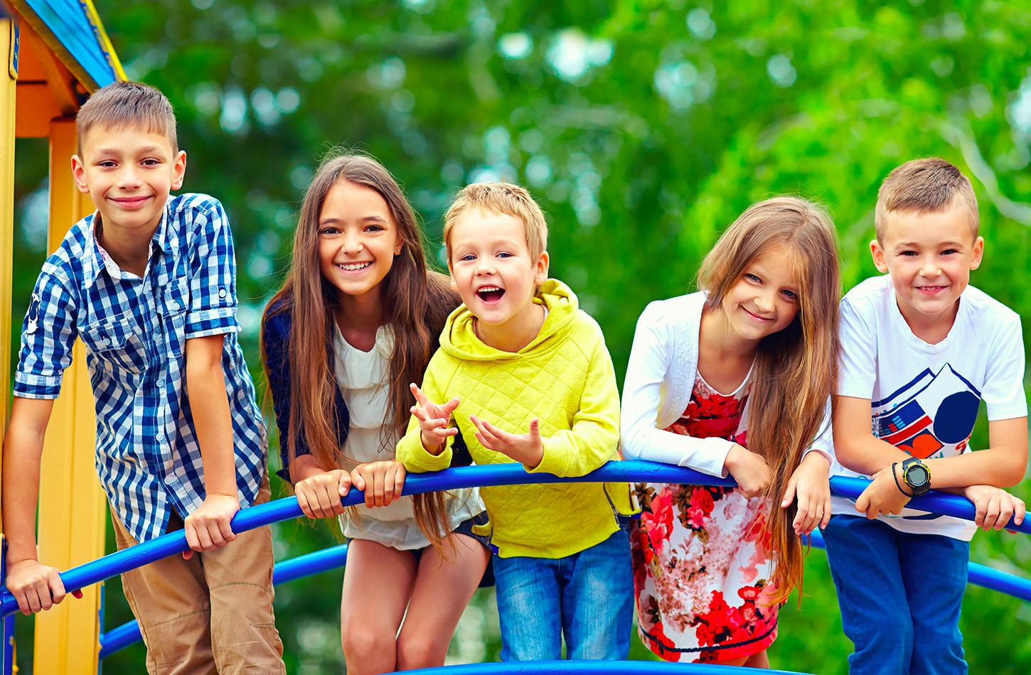 Cinq enfants heureux et enthousiastes s'amusant ensemble sur un module de jeux.