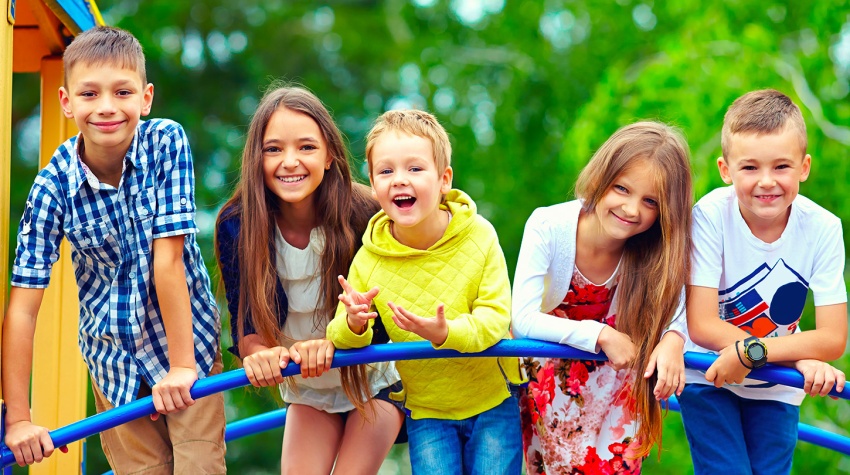 Cinq enfants heureux et enthousiastes s'amusant ensemble sur un module de jeux.